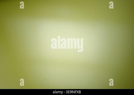 Soft olive green and pale yellow gradient with out-of-focus lighting. The blurred textures represent environmental integration and the subtle shifts w Stock Photo