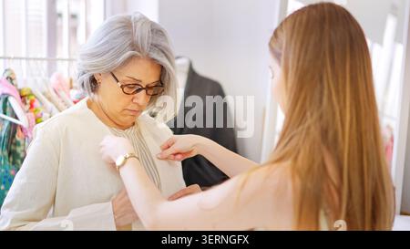 Designer adjusting clothing on a client Stock Photo