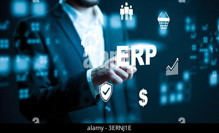 Businessman interacts with ERP system on digital screen showing various icons in modern office Stock Photo