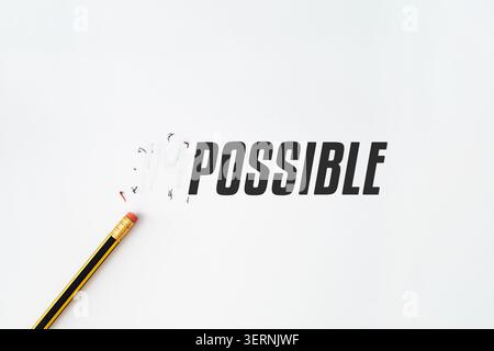 Creative conceptual image showing the word IMPOSSIBLE transformed into POSSIBLE by erasing the negative prefix with a pencil on white background. Stock Photo