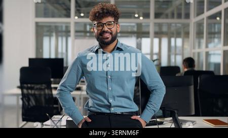 Thoughtful Arabian business man looking away toothy happy smiling at camera ethnic businessman joyful smile stylish successful male executive guy at Stock Photo