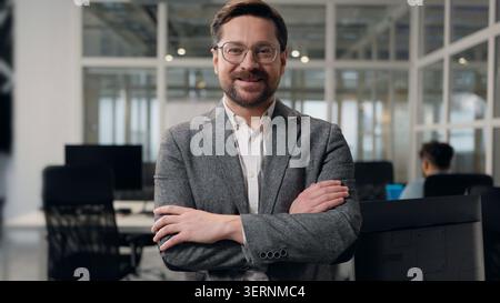 Thinking Caucasian business man smiling happy looking at camera crossed hands posing at office European businessman think smile joyful satisfied male Stock Photo