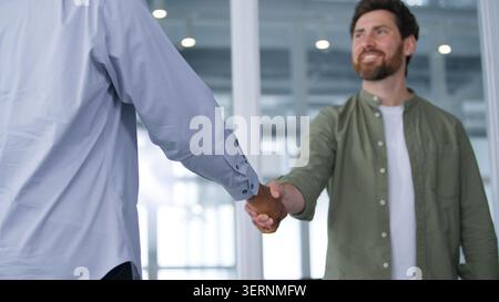 Caucasian talking business man shaking hands with unrecognizable African American businessman two multiracial businessmen diversity males men Stock Photo