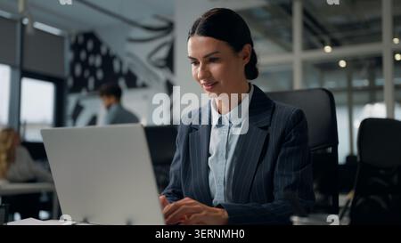 Caucasian business woman typing laptop thinking consider work task adult businesswoman working computer technology startup developing browsing Stock Photo