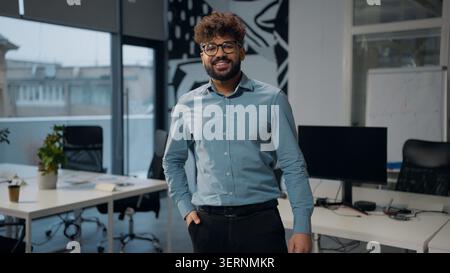 Arabian business man smiling toothy looking at camera posing standing in office ethnic happy adult businessman smile indoors positive male satisfied Stock Photo