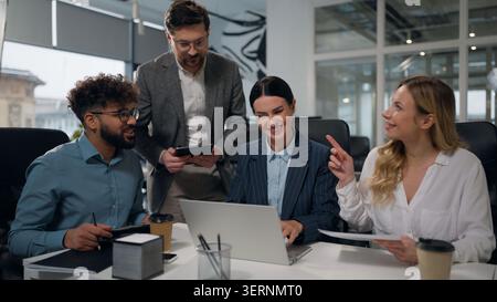 Successful multiethnic business team colleagues talking smiling discussing online project discuss marketing strategy at office meeting multiracial Stock Photo