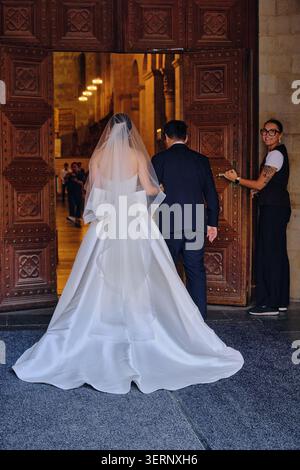 Wedding ceremony entrance with bride and groom walking into a church in Lund, Sweden. Marriage and new beginnings concept, celebrating love and commit Stock Photo