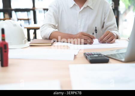 Engineer working with drafting tools and calculator on architect Stock Photo