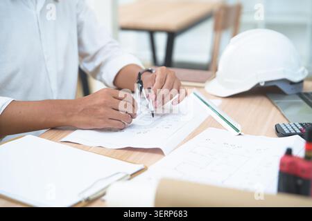 Architect or engineer working on building plans with drafting to Stock Photo