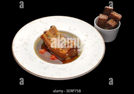 Pork ribs in broth with rye bread croutons Stock Photo