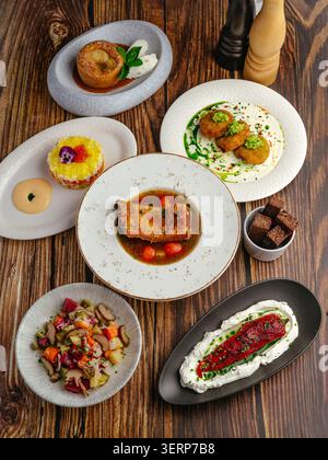 Multiple gourmet dishes served on a wooden tabletop Stock Photo