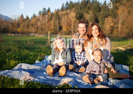 Happy family of five posing for a portrait outdoors Stock Photo