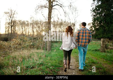 Couple holding hands walking on a country trail Stock Photo