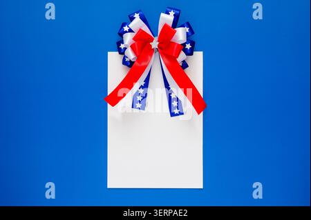 A blank card topped with a festive patriotic bow, ideal for celebrating 250 years of American independence. Stock Photo