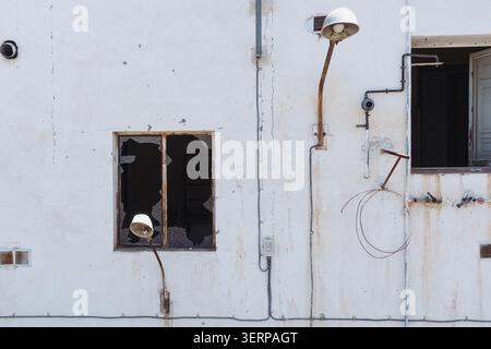 Deteriorated Facade of Vacant Building with Shattered Glass Stock Photo
