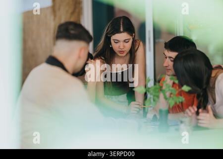 High school students collaborating on a school project around a table in a casual study session Stock Photo