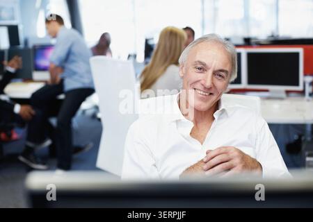 Portrait, business and man in office with computer, career pride and about us for programming. Smile, mature programmer or coworking in workplace with Stock Photo