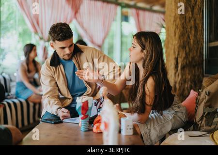 High school students studying and discussing notes together in a casual cafe setting Stock Photo