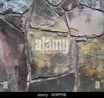 Close up of weathered flat slate and mortar surface with varied slate colors, sizes, and shapes Stock Photo
