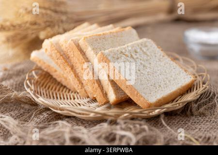 Fresh Sliced White Sandwich Bread on Wicker Basket with Rustic Kitchen Background Stock Photo