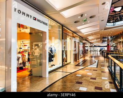 Prague, Czech Republic - June 19, 2026: Interior corridor of a modern shopping mall featuring Tommy Hilfiger and GANT retail stores. Fashion displays Stock Photo