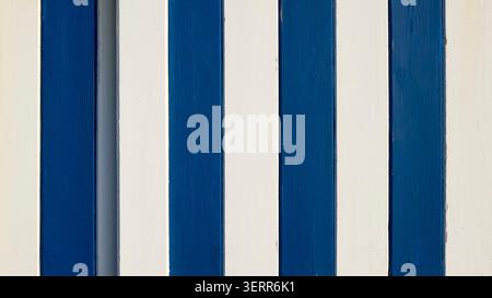 Wooden planks with alternating blue and white paint creating a striped background texture on beach hut door Stock Photo