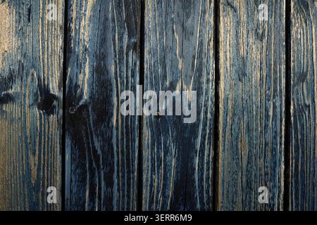 Wooden planks showing rustic grain and peeling blue paint, forming a vintage background surface Stock Photo