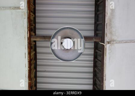Industrial Hanging LED Lamp Under Metal Roof Ceiling with Electrical Wiring, Modern Warehouse and Workshop Lighting Fixture Concept Stock Photo