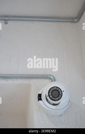 Security camera mounted on wall in indoor area Stock Photo