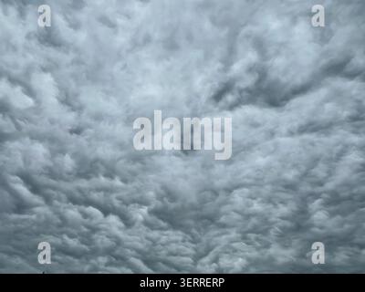 Full frame overcast sky filled with dense layered grey clouds on a cloudy day Stock Photo