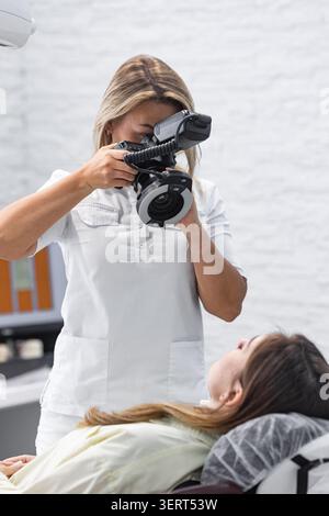 Female dentist using intraoral camera during patient examination in modern clinic Stock Photo