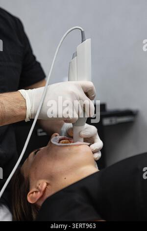 Dentist performing intraoral scanning procedure with digital dental scanner Stock Photo