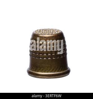 Old classic bronze metal thimble used for hand sewing isolated on a white background Stock Photo