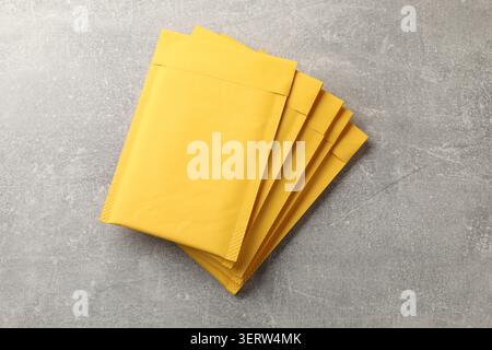 Stack of yellow envelopes on grey table, top view Stock Photo