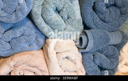 Soft Rolled and Folded Bath Towels Background Texture in Blue and Beige Colors Stock Photo