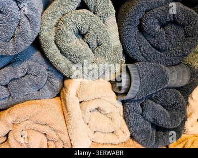 Stack of Soft Rolled Bath Towels in Blue and Beige Tones Background Texture Stock Photo