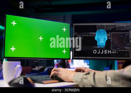 Software programmer watching AI on isolated screen PC gaining consciousness. Computer engineer seeing artificial intelligence talking on chroma key monitor, sitting at desk. Stock Photo