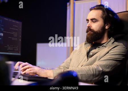 Computer scientist updating artificial intelligence machine learning algorithm, writing binary code scripts; iT specialist in apartment office uses programming to upgrade AI. Stock Photo