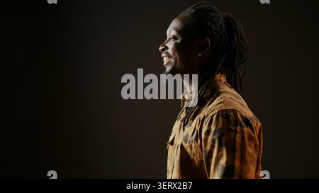 African American man having fun in black studio, laughing at jokes with his friends and enjoying good vibes on camera, young person feeling happy and laughs at funny memes, handheld shot. Stock Photo