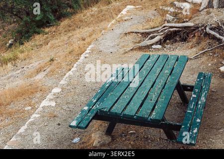 Old picnic table in weathered green color Stock Photo