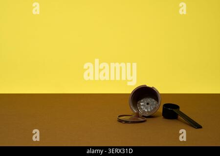 Reusable coffee capsule on brown table with yellow background Stock Photo