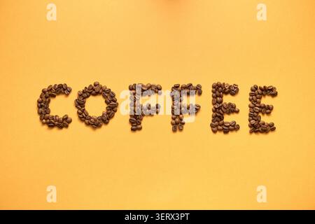"Coffee" Written with Beans on a Yellow Background Stock Photo
