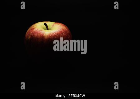 An apple fading in black. Stock Photo