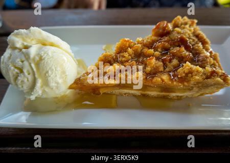 A piece of apple pie with a scoop of cream ice cream. Stock Photo