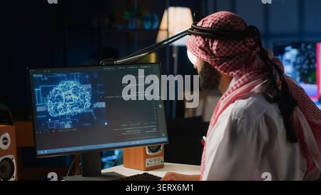 Experienced Arab developer programming scripts on computer screen, employing AI machine learning, manipulating lines of code for artificial intelligence applications computing. Stock Photo