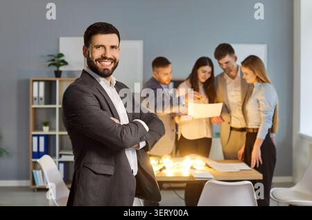 Male leader and young team group gathering thinking around table, examining documents discussing Stock Photo