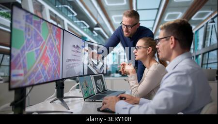 Three Professionals Discuss Local City Planning Using BIM And GIS Software. Stock Photo
