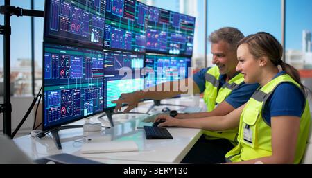 Two Engineers Monitor Industrial Gas Plant Systems Using Advanced Computer Controls. Stock Photo