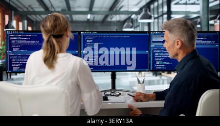 Two Software Engineers Discuss Coding Ideas While Working Together. Stock Photo