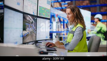 Experienced Logistics Manager Monitors Real-time Package Flow On Multiple Screens Confidently. Stock Photo
